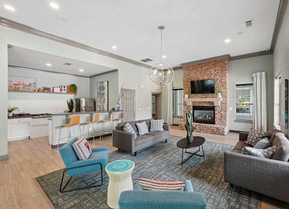 A living room with a fireplace and a grey couch.