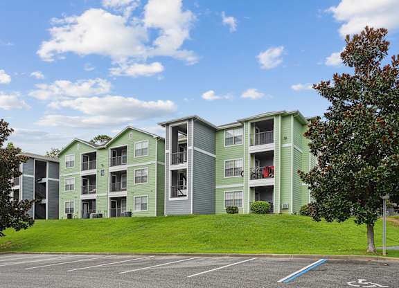 Apartment complex with green and grey buildings.