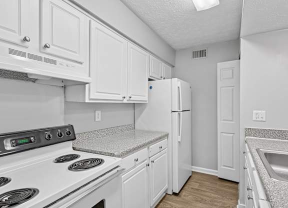A kitchen with white cabinets and appliances.at Magnolia at Whitlock, Marietta, 30064
