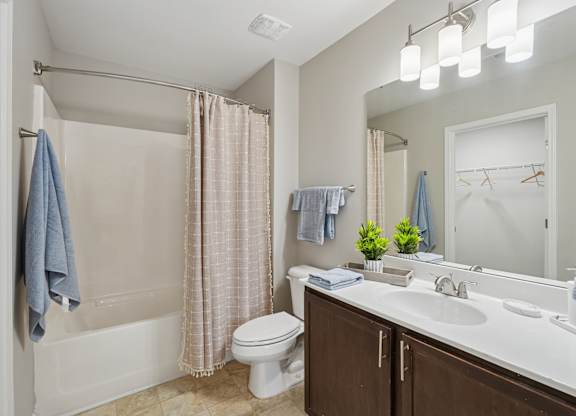 A bathroom with a toilet, sink, and shower.