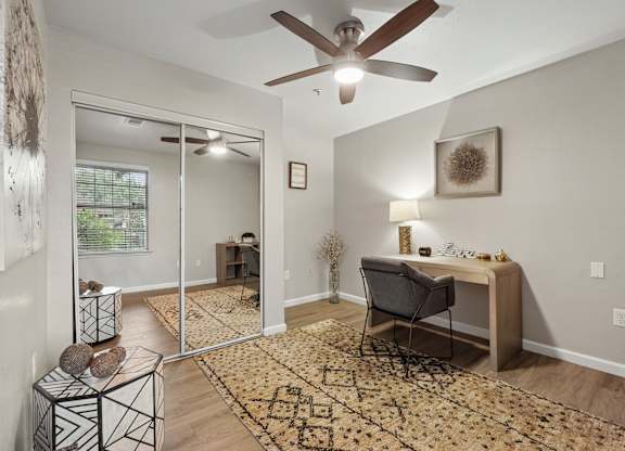A room with a ceiling fan and a chair.