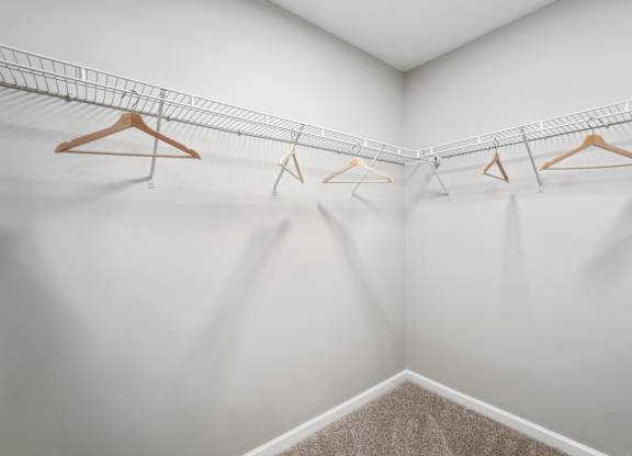 A white room with a clothes rack and hangers.