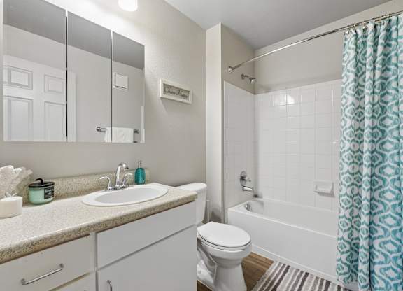A white bathroom with a sink, toilet, and bathtub.
