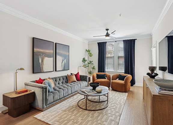 A living room with a grey couch, a coffee table, and a painting on the wall at Union Eleven Apartments, Atlanta, Georgia