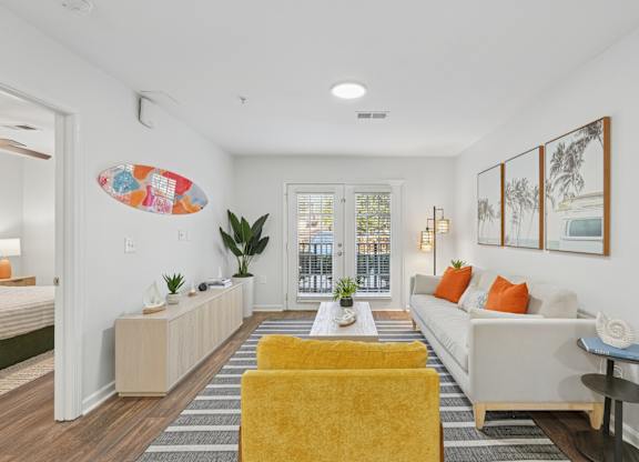 A living room with a yellow chair and a white couch.