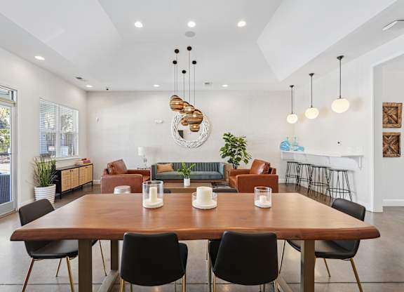 A modern dining room with a large wooden table and chairs.