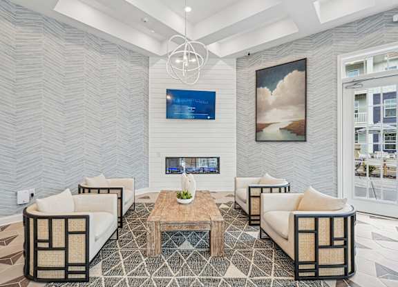A modern living room with a fireplace and a painting on the wall.at The Parker Leland, Leland