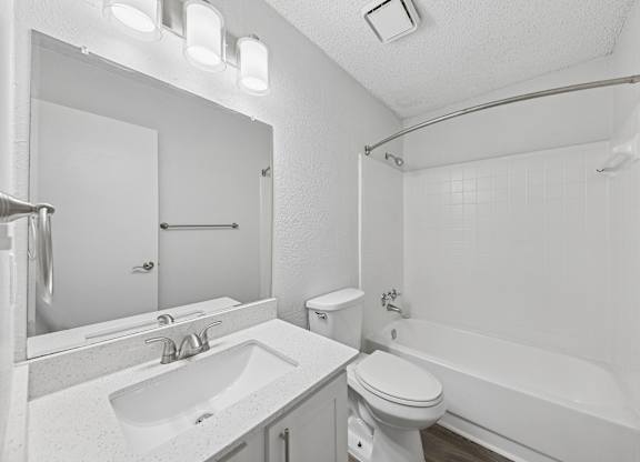 A white bathroom with a sink, toilet, and bathtub.