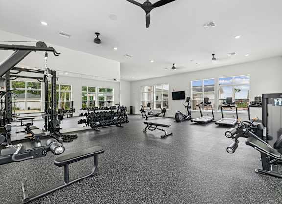 A spacious gym with a variety of equipment and a ceiling fan.at The Exchange at Crestview Apartments, Crestview, 32536