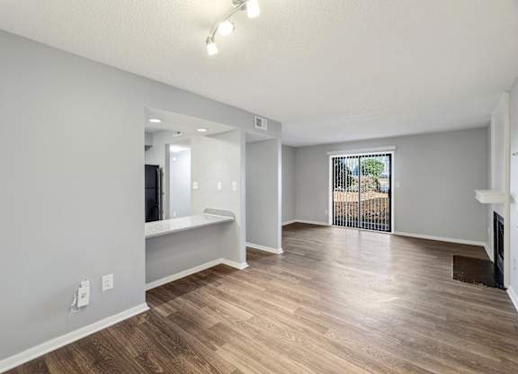 Living room and dining room of an apartment with wood flooring and a balcony  at Governors House, Alabama