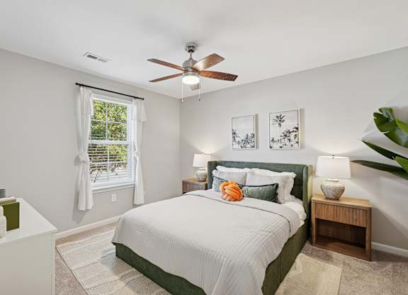 A bedroom with a large bed and a ceiling fan.