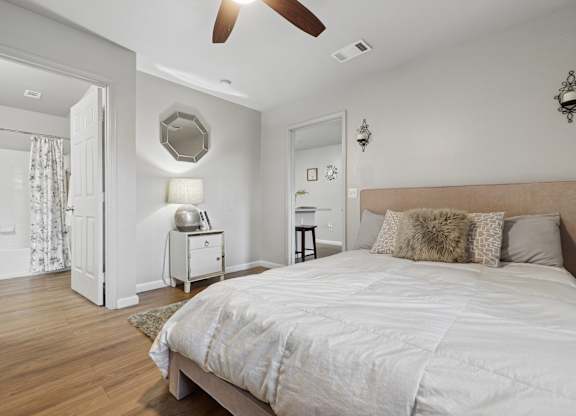 A bedroom with a large bed and a ceiling fan.