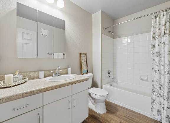 A white bathroom with a sink, toilet, and bathtub.