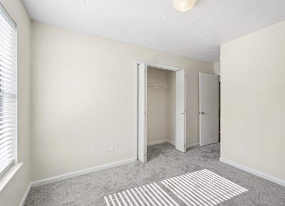 A room with a grey carpet and a white ceiling light.