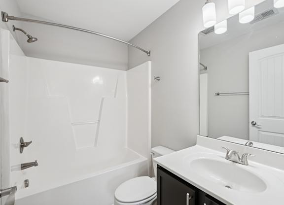 A white bathroom with a toilet, sink, and bathtub.