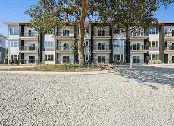 Apartment building with a tree in front.