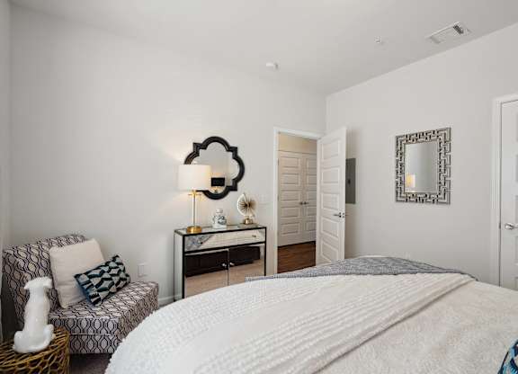 Bedroom with a bed and a chair and a mirror  at The Meadows, Bloomingdale, GA, 31302