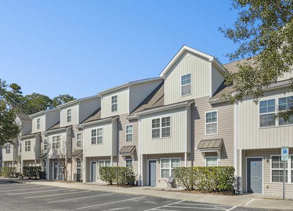 A row of townhouses with a clear blue sky above.