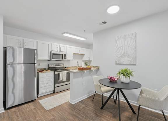A kitchen with a refrigerator, oven, and sink.