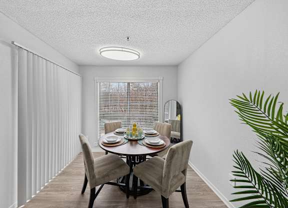 A dining room with a table set for four.