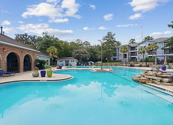 A large swimming pool with a stone building in the background.