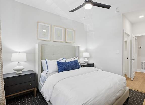 A bedroom with a large bed, a ceiling fan, and a nightstand with a lamp at Union Eleven Apartments, Atlanta, 30324