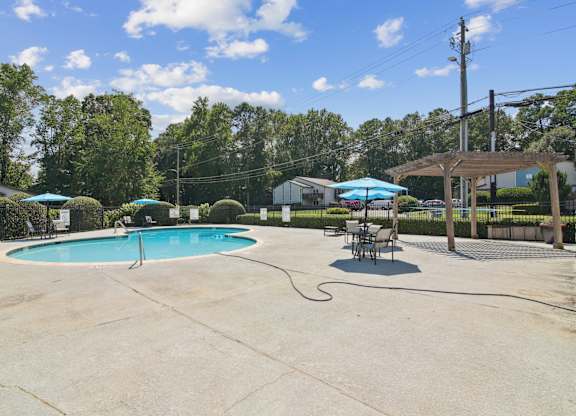 A pool with a hammock and umbrellas at The Taylor, Marietta, GA.