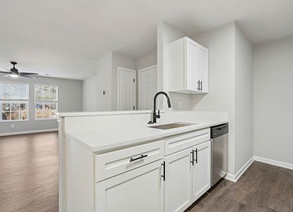 A kitchen with white cabinets and a sink.