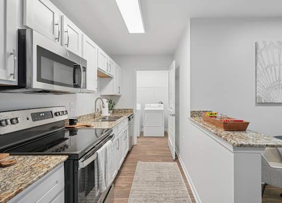 A kitchen with black appliances and white cabinets.