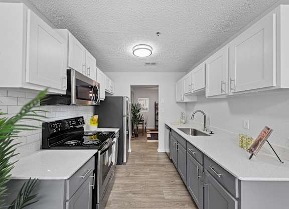 A kitchen with white cabinets and a black stove top oven.