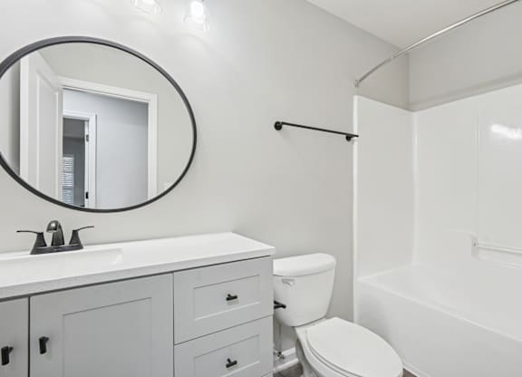 A white bathroom with a toilet, sink, and bathtub.