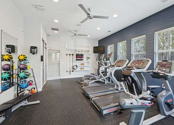 A spacious gym with treadmills, exercise bikes, and other equipment.