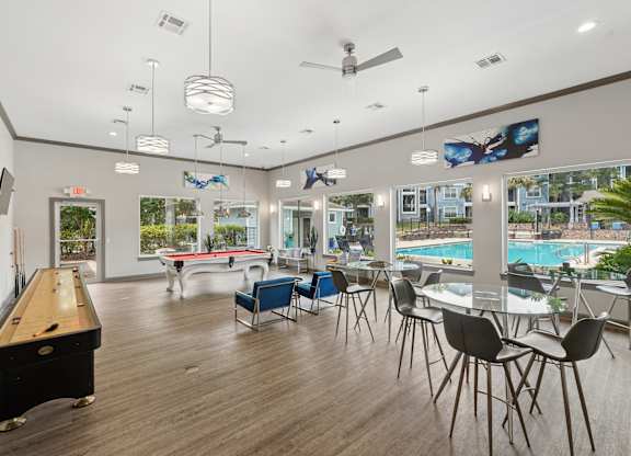 A billiard table is in the middle of a room with a pool table and a television.