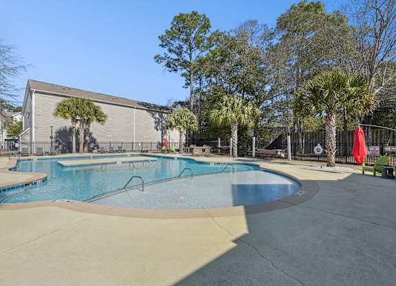A swimming pool with a slide and a building in the background.