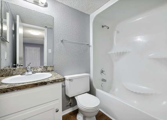 Bathroom with a sink toilet and a bath tub  at Governors House, Huntsville, AL
