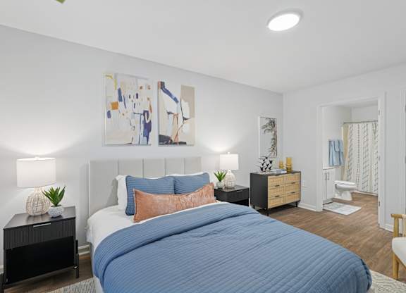 A bedroom with a large bed and a painting on the wall.