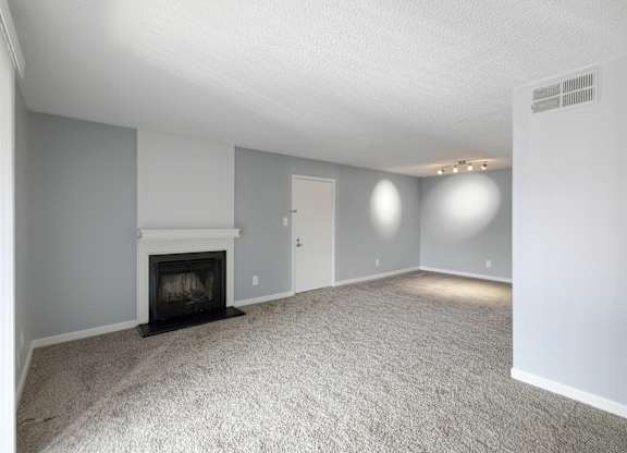 Living room with a fireplace and white carpet  at Governors House, Alabama, 35805