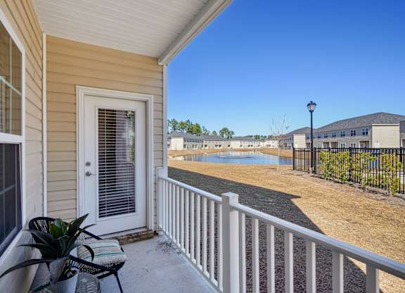 Front porch view of a house with a lake at The Meadows, Georgia, 31302