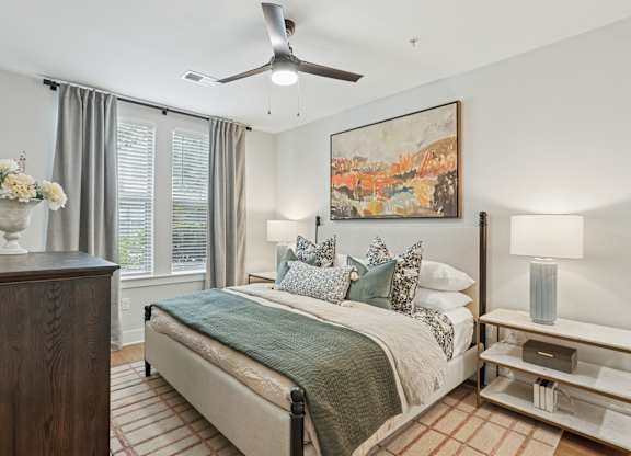 A bedroom with a bed, a dresser, and a painting on the wall at Union Eleven Apartments, Georgia