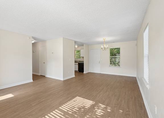 A large, empty room with wooden floors and white walls.