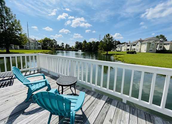 Balcony with two chairs and a table on a deck overlooking a lake at The Chase, Burlington, 27215