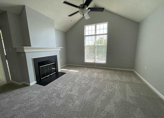 Living room with a fireplace and a ceiling fan at The Chase, Burlington, 27215