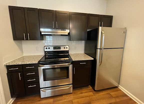Kitchen with stainless steel appliances and black cabinets at The Chase, Burlington, NC