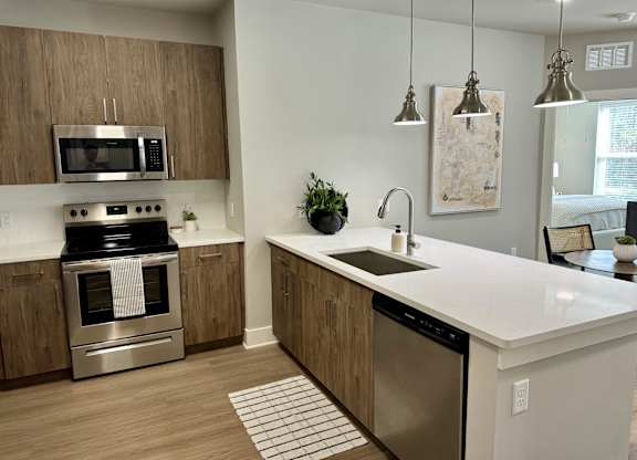 A modern kitchen with a stainless steel oven and a white countertop at The Collective Upper Westside Apartments, Atlanta, GA, 30318