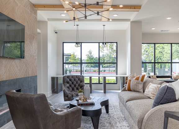 A modern living room with a grey sofa, a black chair, and a coffee table at The Collective Upper Westside Apartments, Atlanta, GA