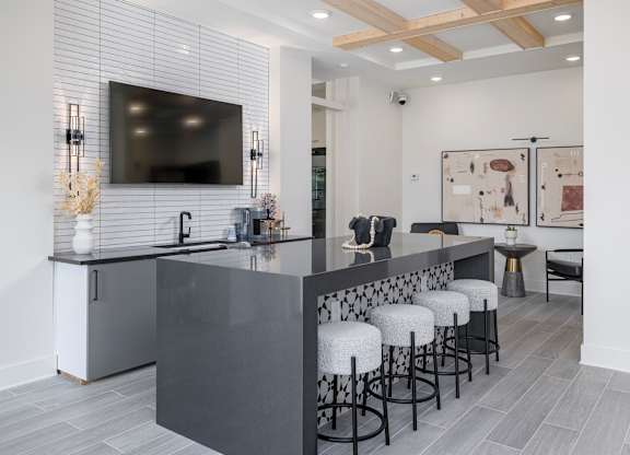 A modern kitchen with a bar area and stools at The Collective Upper Westside Apartments, Georgia