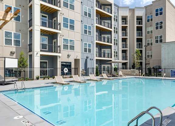 A swimming pool in front of a multi-story apartment building at The Collective Upper Westside Apartments, Atlanta, GA, 30318
