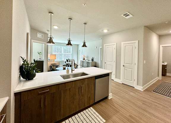 A modern kitchen with wooden cabinets and a white countertop at The Collective Upper Westside Apartments, Georgia, 30318