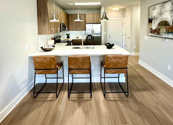 A kitchen with a bar and chairs at The Collective Upper Westside Apartments, Atlanta, Georgia