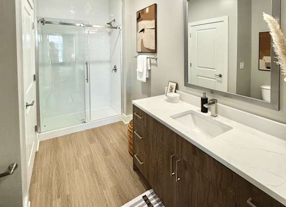 A bathroom with a white sink and a mirror at The Collective Upper Westside Apartments, Atlanta